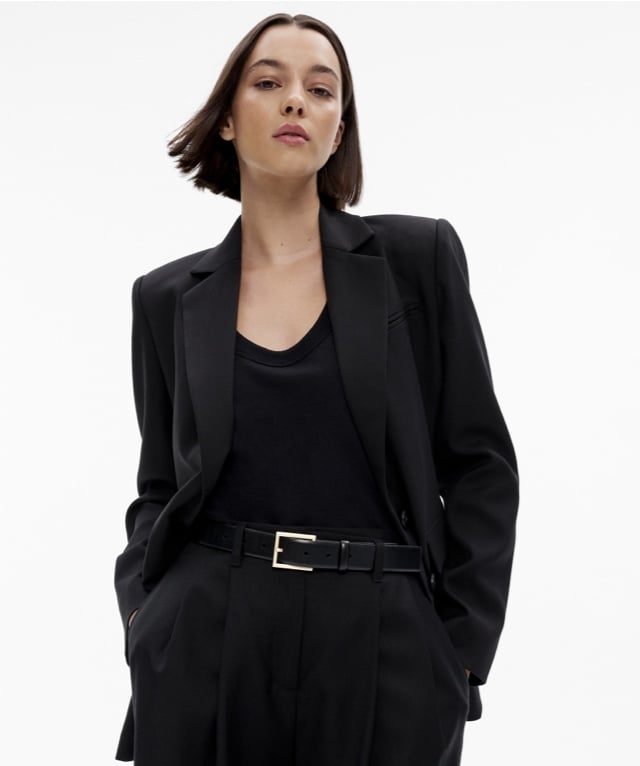 Woman in a black blazer, black tank top and black pants