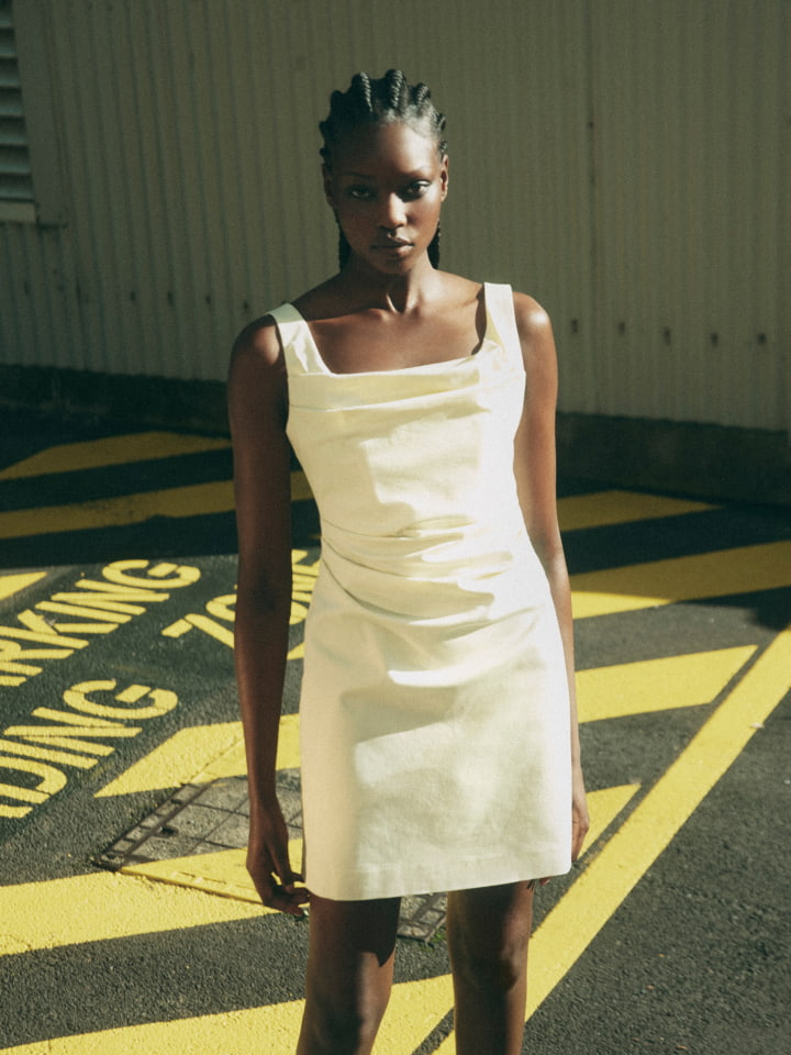 Woman wearing the lemon ruched mini dress