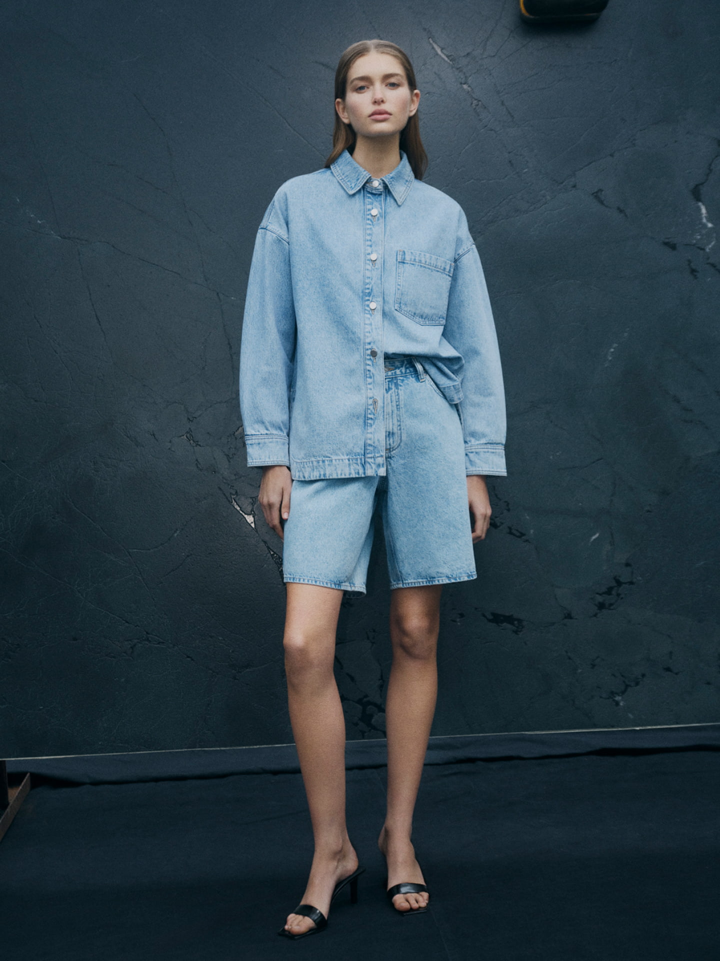 Woman in denim shacket, denim bermuda shorts and black grace mule