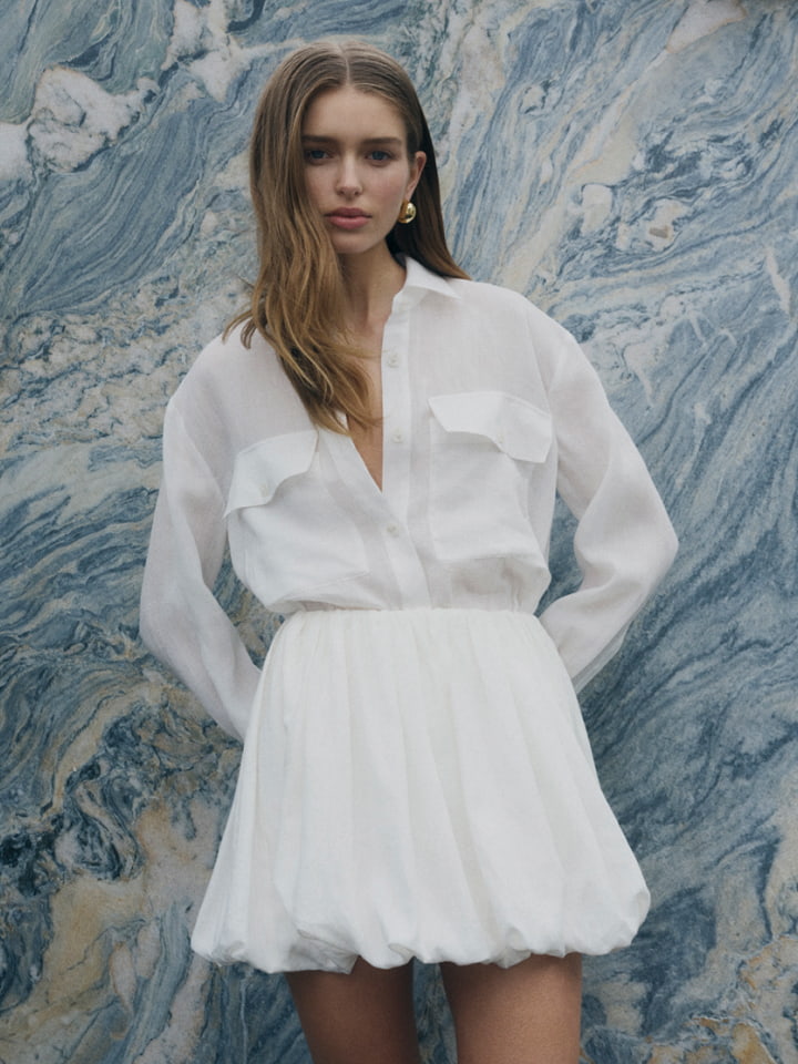 Woman in white utility pocket shirt and white linen bubble skirt